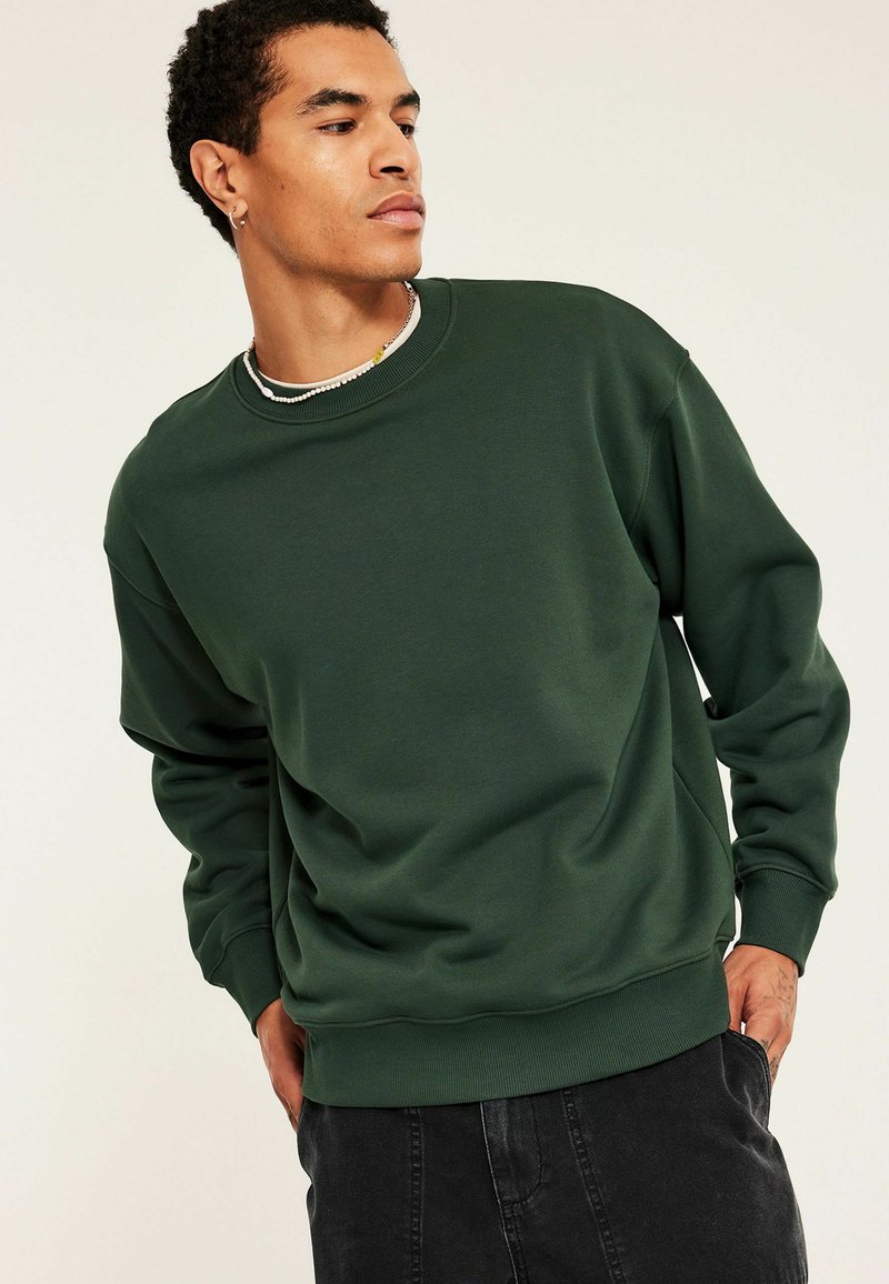 Groene sweatshirt gemaakt van een zachte katoenmix, met een ronde hals, lange mouwen, geribbelde manchetten en een comfortabele pasvorm.