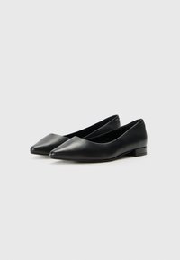 Ballerines en cuir noir avec un bout pointu et un petit talon, présentant une texture lisse et un design simple. Aucune motif ou accent visible.