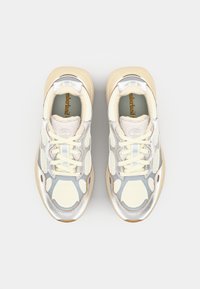 Vita och grå meshsneakers med metalliska silverdetaljer, beige sula och snörningsdesign. Inkluderar en vadderad plös och strukturerade mönster.