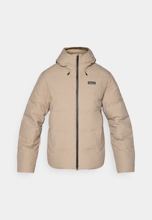 Doudoune beige avec capuche, fermeture éclair et poignets élastiques. Fabriquée en tissu résistant à l'eau, avec un petit logo sur la poitrine.