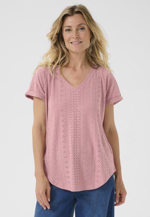 Camiseta corta de manga corta en color rosa con escote en V, que presenta un patrón de ojales, una tela texturizada y un corte relajado que se curva ligeramente en el dobladillo.