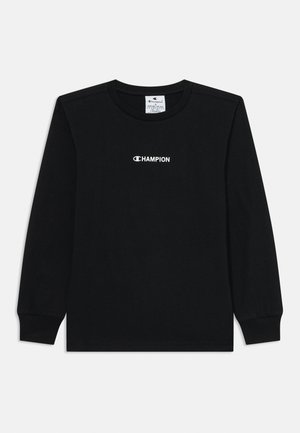 T-shirt noir à manches longues en coton, avec un col rond et un logo "CHAMPION" blanc centré sur la poitrine.