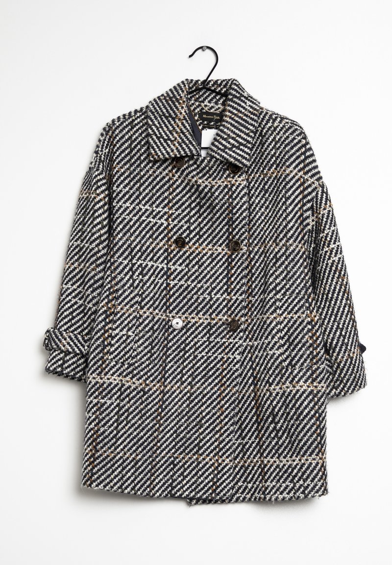 Cappotto doppiopetto in un motivo a scacchi bianco e nero con accenti arancioni, dotato di colletto, bottoni e maniche arrotolate.