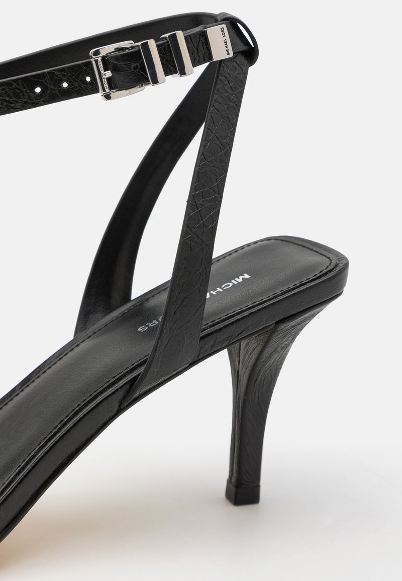 Sandal con tacco alto nero, con tomaia in pelle a trama, cinturini sottili, hardware in argento e design a punta quadrata.