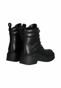 Stivali alla caviglia in pelle nera con suola spessa, chiusura con lacci e cerniera. Presentano un manico e dettagli testurizzati sui lati.