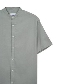 Chemise à manches courtes en tissu gris clair. Présente un col mao, une fermeture boutonnée à l'avant et des détails de couture nets et minimalistes.