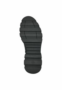 Black rubber shoe sole with a ribbed texture, featuring rectangular patterns and a circular heel, branded with “Tamaris” near the center.
