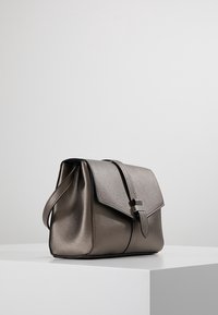 Borsa a mano in pelle metallizzata grigia con una forma strutturata, chiusura con patta, tracolla regolabile e dettagli in metallo color argento.