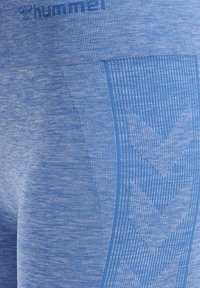 Modré sportovní legíny s texturovanou tkaninou a melírovaným vzorem. Na boku se nachází vertikální pruh a design ve tvaru šípu.