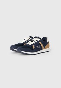 Navy sneakers featuring a mesh upper and suede accents in brown, white laces, and a white midsole. Rubber outsole for traction.