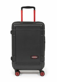 Černý hard-shell cestovní kufr s texturovaným povrchem, červenými koly a teleskopickou rukojetí. Na přední straně se nachází logo EASTPAK a ochranné rohové akcenty.
