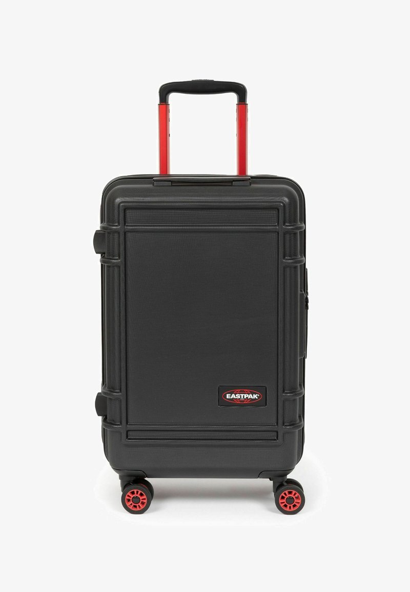 Černý hard-shell cestovní kufr s texturovaným povrchem, červenými koly a teleskopickou rukojetí. Na přední straně se nachází logo EASTPAK a ochranné rohové akcenty.