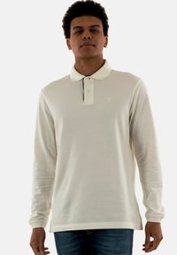 Polo-shirt met lange mouwen in off-white, met een klassieke kraag, drie knoopsluiting en een subtiele logo op de linkerborst. Geweven stof.