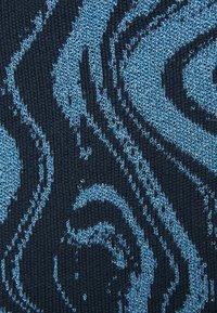 Tecido de malha azul e preto com um padrão espiral, apresentando fios texturizados e de espessuras variadas, criando um efeito visual dinâmico.