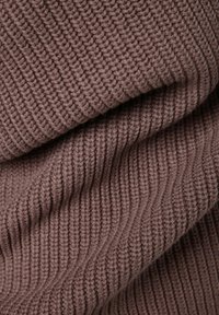 Tessuto lavorato a maglia marrone con una texture a coste e linee diagonali, che mette in risalto un materiale morbido e spesso.