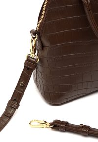 Bruine krokodillenembossed leren tas met een gouden rits, een bevestigde strap en een gladde textuur. Opvallende hardwareaccenten zijn een haaksluiting.