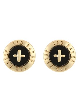 Boucles d'oreilles rondes Ted Baker ton or avec centres noirs et un motif en forme de croix au centre, nom de la marque gravé autour des bords.