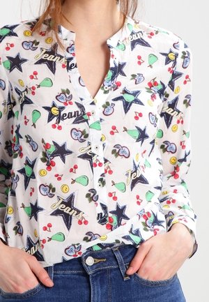 Wit overhemd met knopen, voorzien van een kleurrijke print van sterren, fruit en smiley gezichten, in tinten blauw, groen en rood. Zachte, lichte stof.