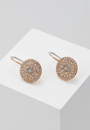 Boucles d'oreilles rondes en or rose avec des cristaux clairs groupés disposés en cercle, présentées sur un socle blanc incliné.