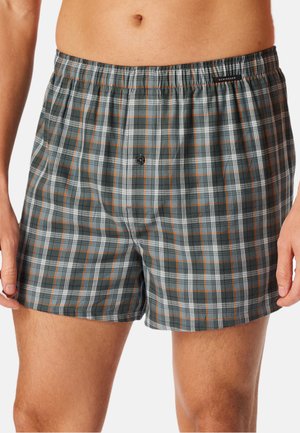 Männliche karierte Boxershorts in Dunkelgrau mit weißen und orangefarbenen Akzenten, ausgestattet mit einem elastischen Bund und einem einzigen Knopfverschluss.