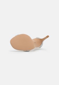 Sølvhælede sandaler med en glat beige sål, der har en buet form og udsmykkede remme prydet med små rhinsten.