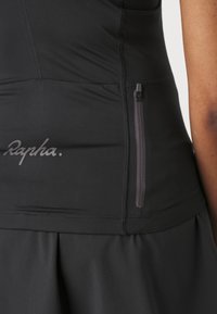 Haut de sport noir en tissu texturé, avec une poche zippée latérale et le mot "Rapha" imprimé en contraste mat.