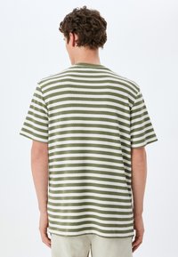 Grön- och vitrandig kortärmad t-shirt i strukturerad tyg, med rund hals och avslappnad passform.