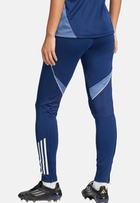 Marineblaue Sportleggings mit engem Schnitt, ausgestattet mit hellblauen Akzenten und diagonalen Mustern. Enthält weiße Streifen entlang des Unterschenkels.