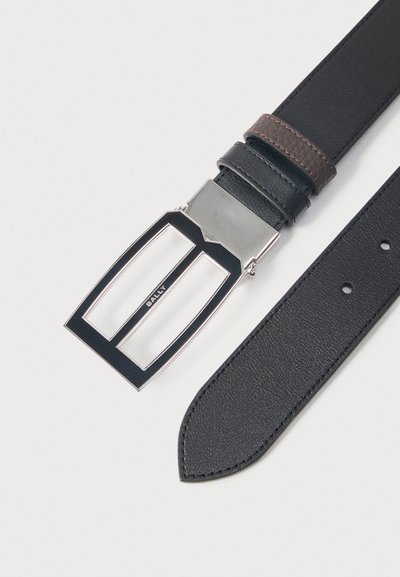 Μαύρη δερμάτινη ζώνη με ασημένια ορθογώνια πόρπη με ανοιχτό πλαίσιο και ελαφρώς μυτερή άκρη, εμφανιζόμενη σε ανοιχτό φόντο.