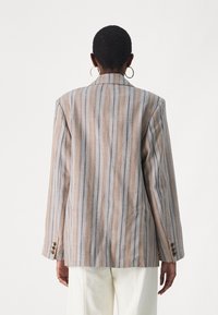 Stripet blazer i beige, blå og grå toner. Har smal passform, strukturerte skuldre og treknappsgjennomganger. Glatt tekstur.