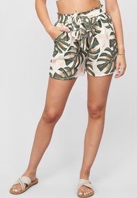 Lightweight, beige shorts with green tropical leaf pattern, cinched elastic waistband, tie detail, and side pockets.