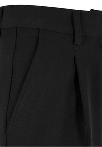 Pantaloni negri croiți, cu o textură netedă, față plată și plii subtile. Materialul pare ușor și elastic.