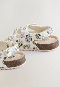 Witte sandalen met een patroonontwerp featuring cartoonfiguren. Verstelbare bandjes en een kurkachtig bruin zool.