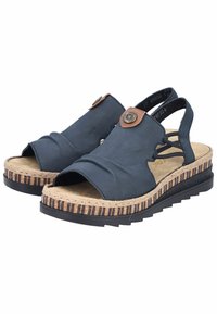 Granatowe sandały z odkrytymi palcami i elastycznymi paskami, z teksturowaną korkową podeszwą i brązowym okrągłym akcentem z przodu.