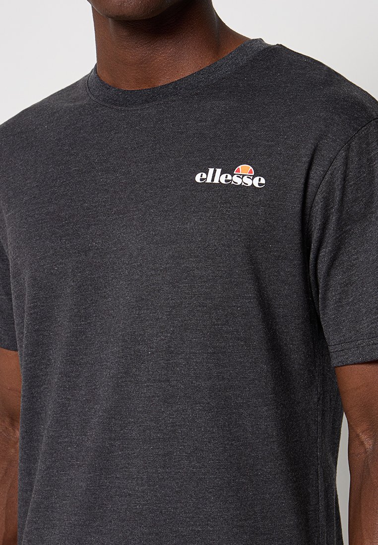 Czarna koszulka z krótkim rękawem wykonana z bawełny, z okrągłym dekoltem; na piersi znajduje się białe logo "ellesse" oraz kolorowy półokrągły akcent.