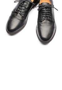 Scarpe eleganti in pelle nera con una texture liscia, design con lacci, punta rotonda e dettagli di cucitura minimi per un aspetto elegante.