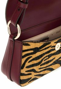 Sac en cuir bordeaux avec un motif de rayures de tigre texturé jaune et noir à l'avant. Il dispose d'une fermeture à pression en métal doré et d'une bandoulière réglable.