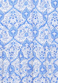 Textile bleu et blanc avec des motifs floraux et géométriques répétitifs complexes dans différentes nuances de bleu sur un fond blanc.