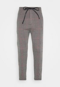 Ruudulliset housut mustavalkealla, joissa on punaisia yksityiskohtia; kapeat mallit; elastinen vyötärö nauhalla; teksturoitu kangas, jossa on ruutukuvio.