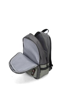 Grijze rugzak met een zachte, gevoerde binnenkant. Hij heeft een dubbele rits, verstelbare banden en een getextureerd onderste compartiment.