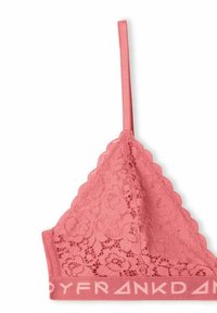 Bralette in pizzo rosa con bordi ondulati, spalline regolabili e una fascia elastica a contrasto con testo stampato lungo il fondo.