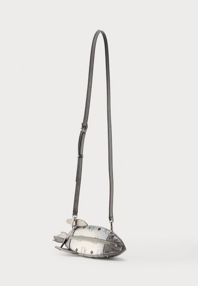 Μικρή μεταλλική ασημί τσάντα χιαστί σε σχήμα ψαριού, με φερμουάρ και ρυθμιζόμενο μακρύ ιμάντα, σε λευκό φόντο.