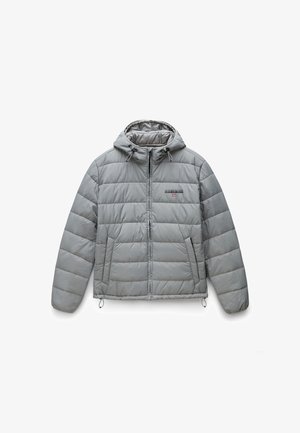 Lichtgrijze pufferjack met capuchon, voorzien van een horizontaal quiltpatroon, ritssluiting aan de voorkant en twee zijzakken. Trektouwen aan de zoom.