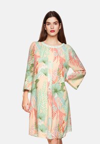 Blumendruckkleid mit pastellpfirsichfarbigem Hintergrund, versehen mit grünen und korallfarbenen Blättern, runder Ausschnitt und Dreiviertelärmeln.