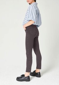 Grijze denim skinny jeans met een hoge taille, gecombineerd met een blauw-wit gestreept shirt en zwarte platform schoenen. Zachte textuur, strakke pasvorm.