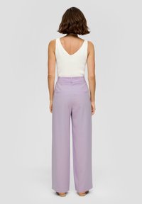 Licht lavendelkleurige vergelijkbare trouser met een hoge taille, twee achterzakken en een gladde textuur, gecombineerd met een wit mouwloos top.