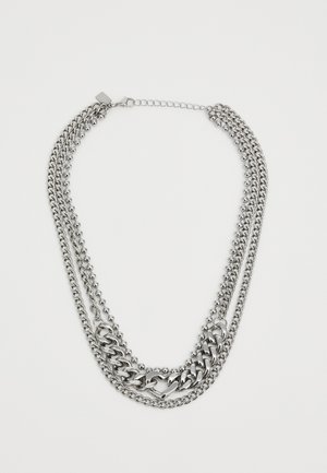 Silver multi-layered chain necklace featuring varying chain styles, round beads, and a clasp closure. Smooth metal texture with shiny finish.