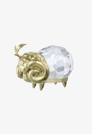 Guldoljat metallisk dekorativ figur med bock-lika drag och en fasetterad kristallkropp, med en liten bladdetalj och tre ben.