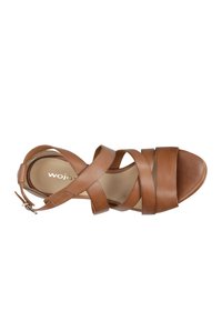 Bruine leren sandalen met kruisbanden en enkelgesp. Open teen ontwerp, gladdige textuur en gevoerd voetbed. Merkwaarde zichtbaar aan de binnenkant.