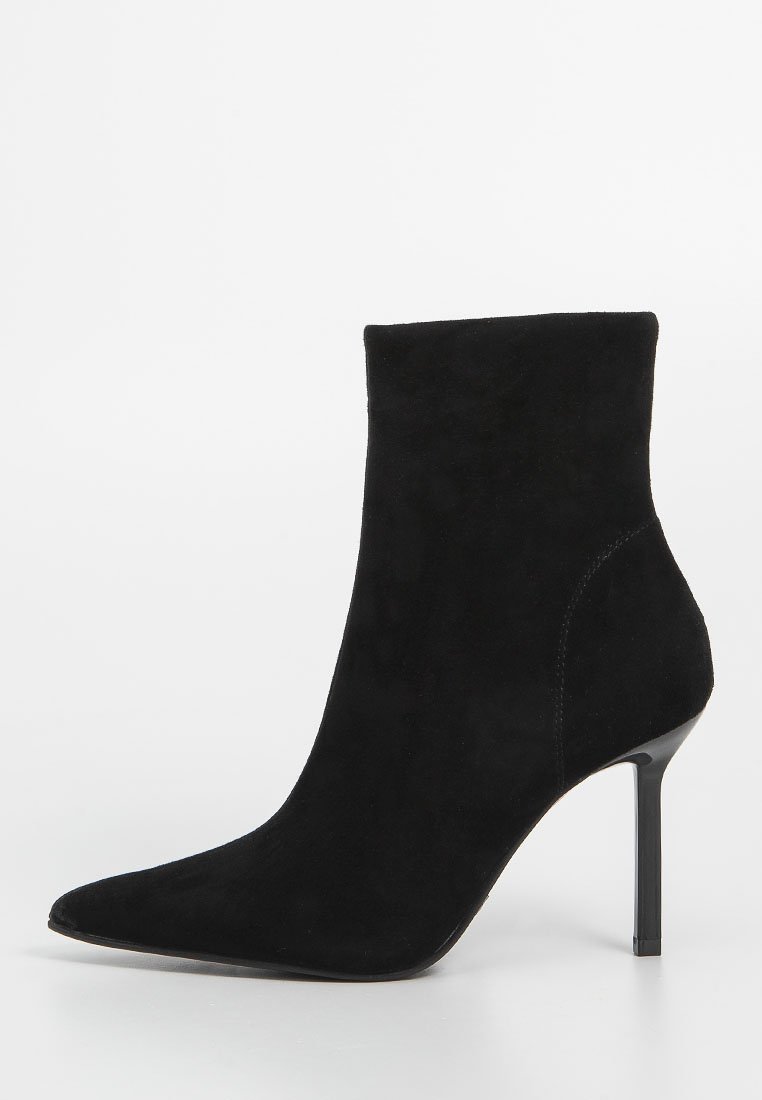 Schwarze Wildleder-Ankle-Boots mit einer spitzen Zehe und einem schlanken Stiletto-Absatz. Glatte Textur und minimalistisches Design mit einer eleganten Silhouette.